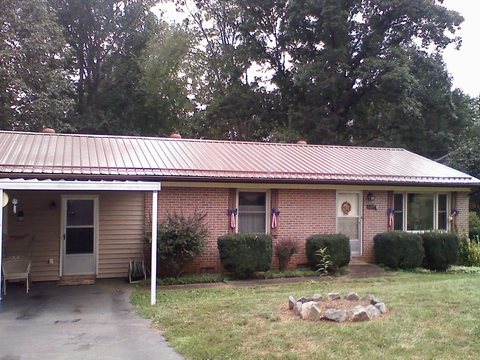Bronze metal roof and carport on a brick ranch home — Roof Repair work by our crew in Seneca